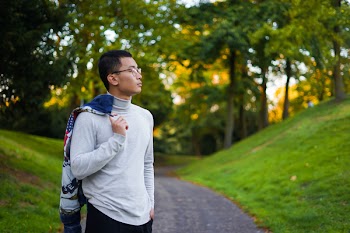 Selective Focus Photography of Man Standing Near Green Grass and Trees