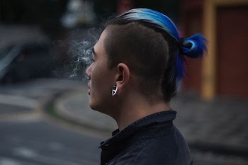 selective focus photography of man with blue mohawk hair