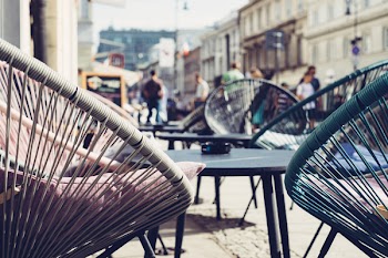 Selective Focus Photography of Patio Set Near Walking People