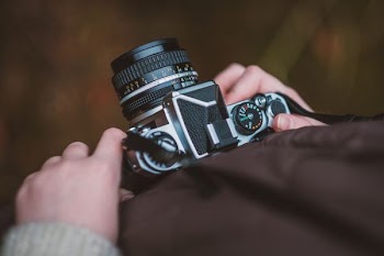 selective focus photography of person carrying camera