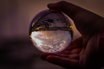 Selective Focus Photography of Person Holding Glass Ball