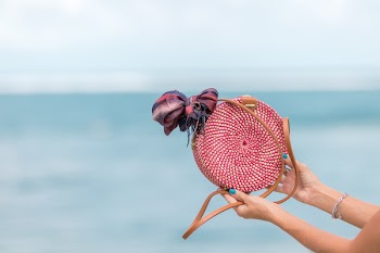 Selective Focus Photography of Person Holding Red and Brown Leather Crossbody Bag