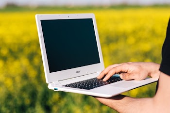 Selective Focus Photography of Person Holding Turned-off Laptop Computer