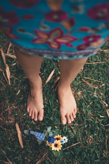 Selective Focus Photography of Person in Front of Yellow Petaled Flowers