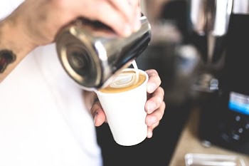 selective focus photography of person pouring coffee on cup