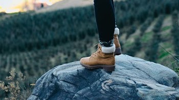 selective focus photography of person standing on rock