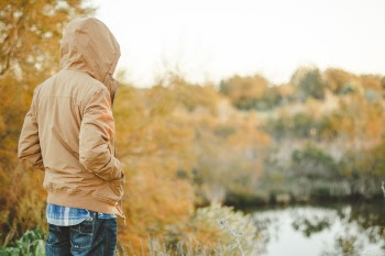 Selective Focus Photography of Person Standing While Facing Body of Water