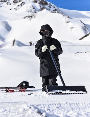 Selective Focus Photography of Person Wearing Snow Suit Using Snow Shovel