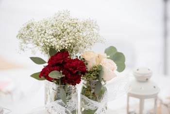 Selective Focus Photography of Red Carnation Flowers, White Hybrid Tea Rose Flowers, and Baby's Breath Flowers in Jar