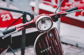 Selective Focus Photography Of Red Vespa Motor Scooter