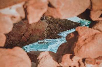 Selective Focus Photography of Rock Formation Near Body of Water