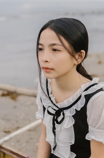 Selective Focus Photography of Sitting Girl Wearing Black and White Shirt