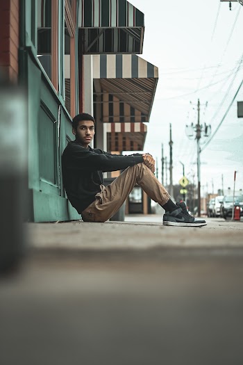 Selective Focus Photography of Sitting Man Leaning on Wall