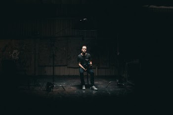 Selective Focus Photography of Sitting Man on Dimmed Lighted Room