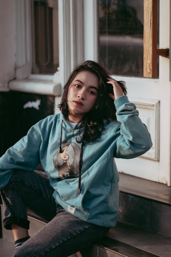 Selective Focus Photography of Sitting Woman Touching Hair