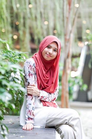 Selective Focus Photography Of Smiling And Sitting Woman Wearing Red Hijab