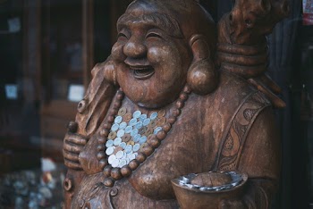 Selective Focus Photography of Smiling Buddha Statue