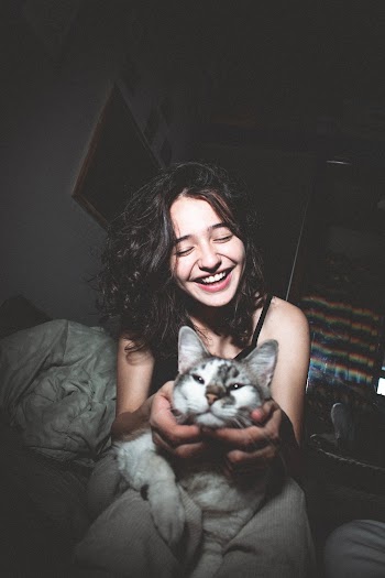 Selective Focus Photography of Smiling Girl Holding Cat