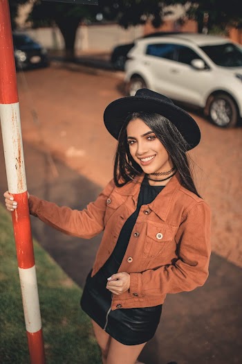 Selective Focus Photography of Smiling Woman Holding on Metal Tube