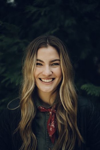 selective focus photography of smiling woman wearing button-up shirt