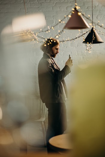 Selective Focus Photography of Standing Man Under Pendant Lamps Using Smartphone