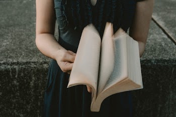 Selective Focus Photography of Standing Woman Flipping Pages of Book