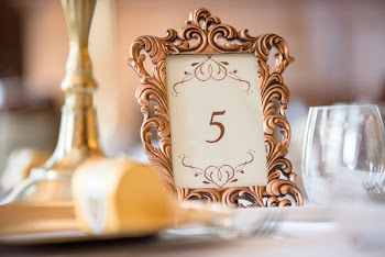Selective Focus Photography of Table Number 5 Inside Scrolled Photo Frame on Table