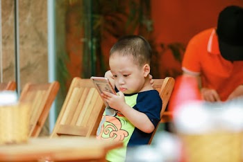 Selective Focus Photography of Toddler Holding Smartphone