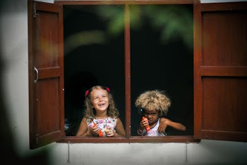 Selective Focus Photography of Two Girls on Window