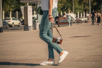 Selective Focus Photography of Woman Carrying Brown Camera