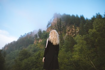 Selective Focus Photography of Woman Facing Mountain