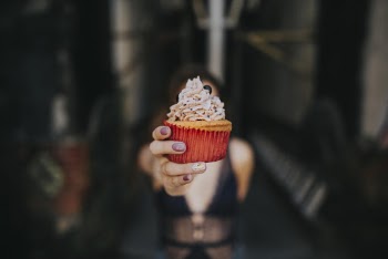Selective Focus Photography Of Woman Holding Cupcake
