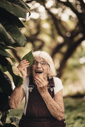 Selective Focus Photography of Woman Holding Green Leaf