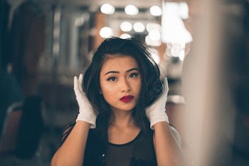 selective focus photography of woman holding her hair
