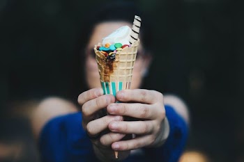 selective focus photography of woman holding ice cream on cone