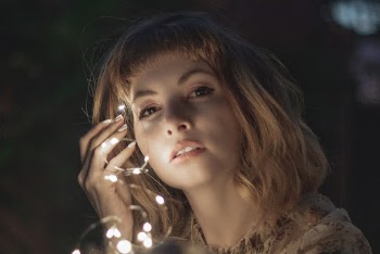 Selective Focus Photography of Woman Holding String Lights during Nighttime
