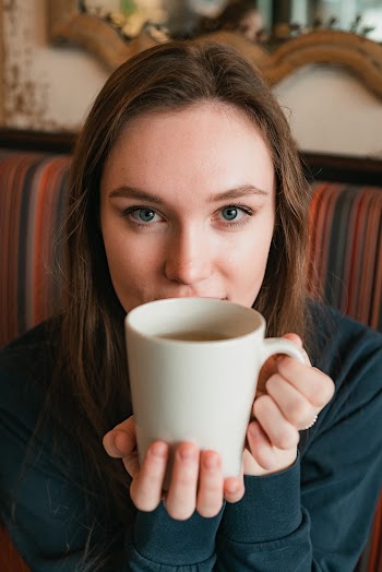 Selective Focus Photography Of Woman Holding White Ceramic Mug