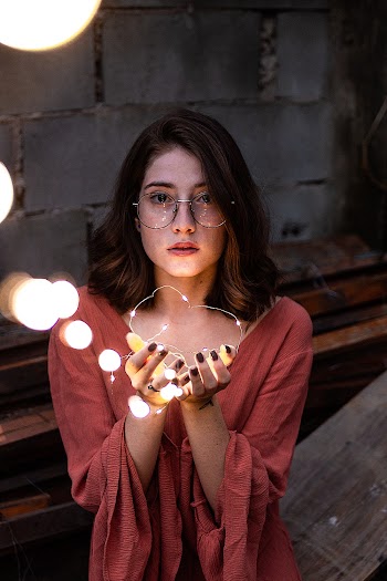 Selective Focus Photography of Woman Holding Yellow String Lights