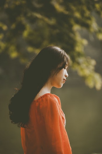 Selective Focus Photography Of Woman In Orange Shirt