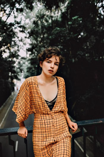 Selective Focus Photography of Woman Leaning on Rail