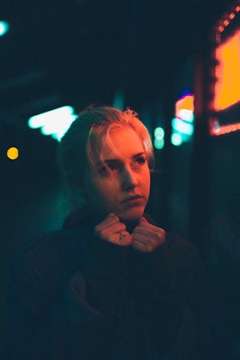 selective focus photography of woman looking sideway while hands on chin