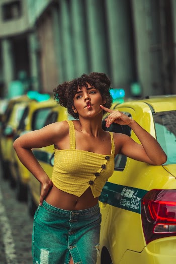 Selective Focus Photography of Woman Pouting Her Lips While Leaning on Taxi