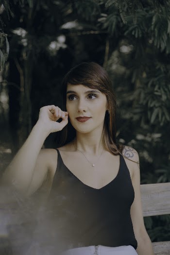 Selective Focus Photography of Woman Sitting on Brown Wooden Bench