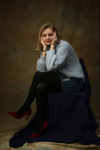 Selective Focus Photography of Woman Sitting on Chair While Holding Her Face