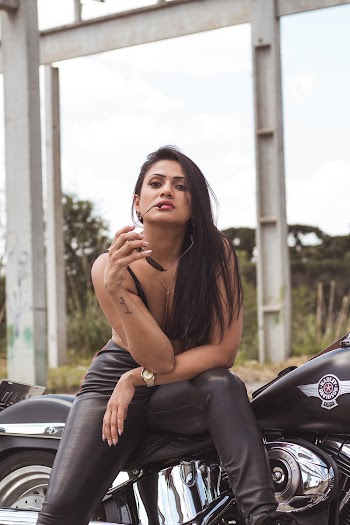 Selective Focus Photography of Woman Sitting on Motorcycle While Holding Sunglasses