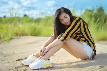 Selective Focus Photography of Woman Sitting On Sand Near Green Grass