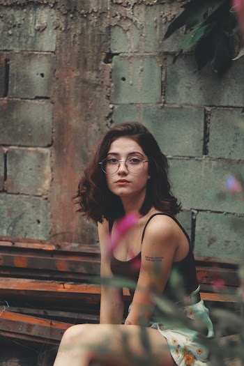 Selective Focus Photography Of Woman Sitting Wearing Black Camisole