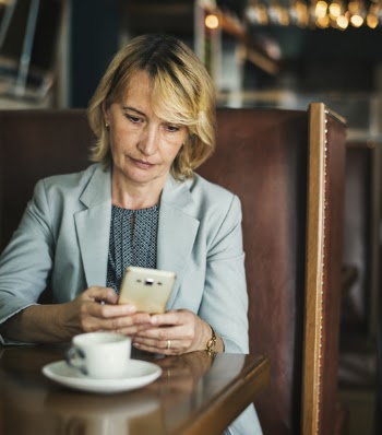 Selective Focus Photography Of Woman Sitting While Using Smartphone