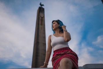 Selective Focus Photography of Woman Sitting With Obelisk in Background