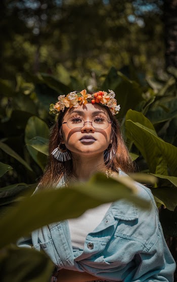 Selective Focus Photography of Woman Standing Beside Green Plant